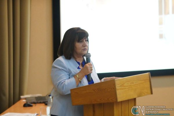 Kobieta w żakiecie przemawiająca na mównicy