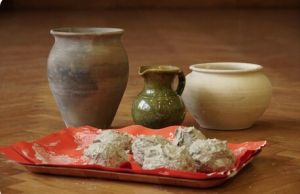 Trzy naczynia gliniane, na tacce kulki z gliny