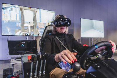 Kobieta w googlach vr siedząca na symulatorze