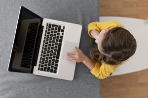 Dziewczynka korzysta z laptopa.