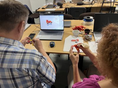 Mężczyzna wraz z kobietą projektujący model 3D w programie komputerowym