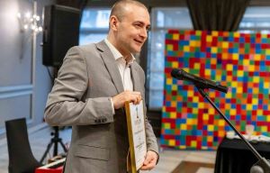 Mężczyzna pokazuje dyplom.