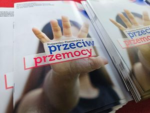 Broszury z otwartą dłonią na okładce oraz napisem: Kujawsko-Pomorskie przeciw przemocy.