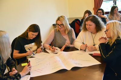 Zebrani na szkoleniu rysujący flamastrami na dużej kartce