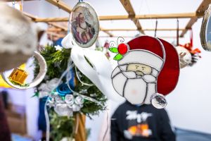 Ozdoby choinkowe wiszące na wystawie, na pierwszym planie św. Mikołaj.