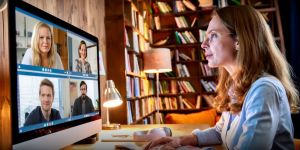 Kobieta przed ekranem podczas webinarium. W tle regały z książkami.