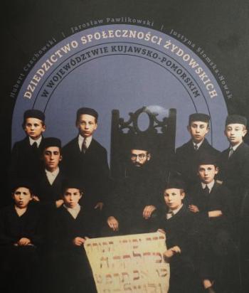 Plakat wystawy - rabin siedzący na krześle, po jego obu bokach odświętnie ubrani uczniowie trzymają zapisaną kartę.