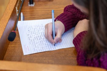 Zbliżenie na kobietę piszącą dyktando.