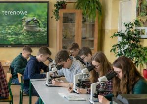 Pracownia do nauki biologii. Uczniowie obserwują preparaty pod mikroskopem.