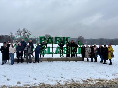 Uczestnicy wizyty pozujący do zdjęcia przy szyldzie "Park Śląski"