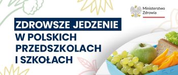 Owoce, warzywa i pieczywo w pojemniku na banerze "Zdrowsze jedzenie" z logo Ministerstwa Zdrowia.