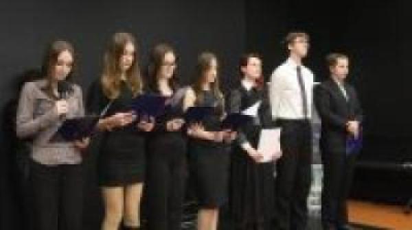 Elegancko ubrana młodzież występuje na scenie.