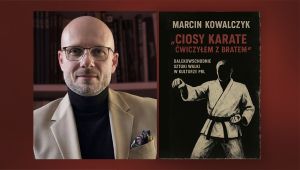 Mężczyzna w okularach, obok książka jego autorstwa.