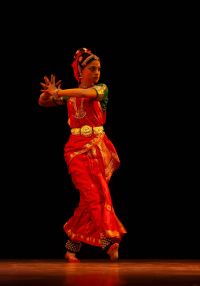 Tańcząca kobieta w barwnym stroju.