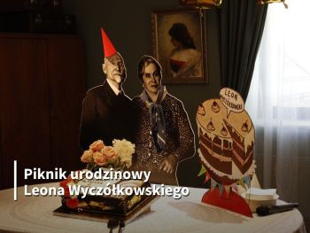 Malarz w papierowej czapce z żoną przy stole z tortem - zdjęcie z elementami grafiki.