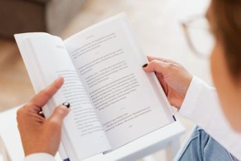 Otwarta książka trzymana przez kobietę.