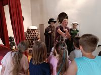 Mężczyzna w muzeum opowiada dzieciom o Koperniku.