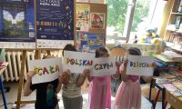Dzieci pokazują kolorowy napis: Cała Polska Czyta Dzieciom.