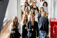 Ubrane na galowo uczennice na korytarzu szkoły.