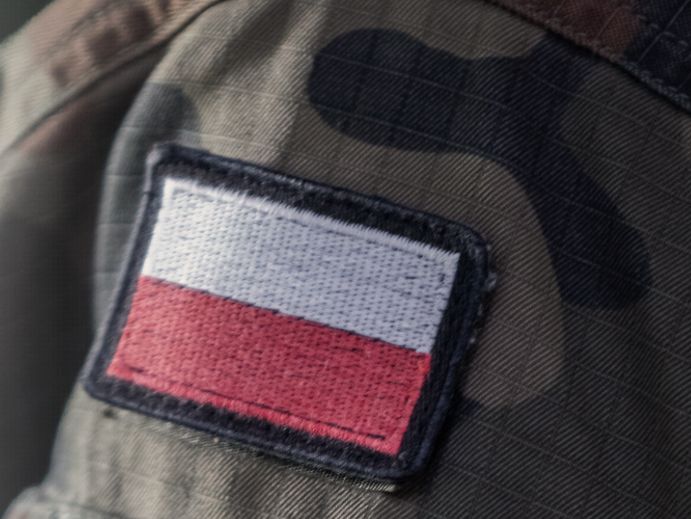 Zbliżenie na naszywkę biało-czerwoną na mundurze moro.