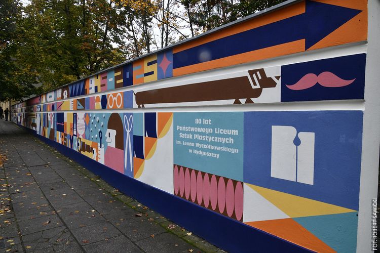 Kilkudziesięciometrowy okolicznościowy mural na ogrodzeniu z okazji 80-lecia Liceum Sztuk Plastycznych.