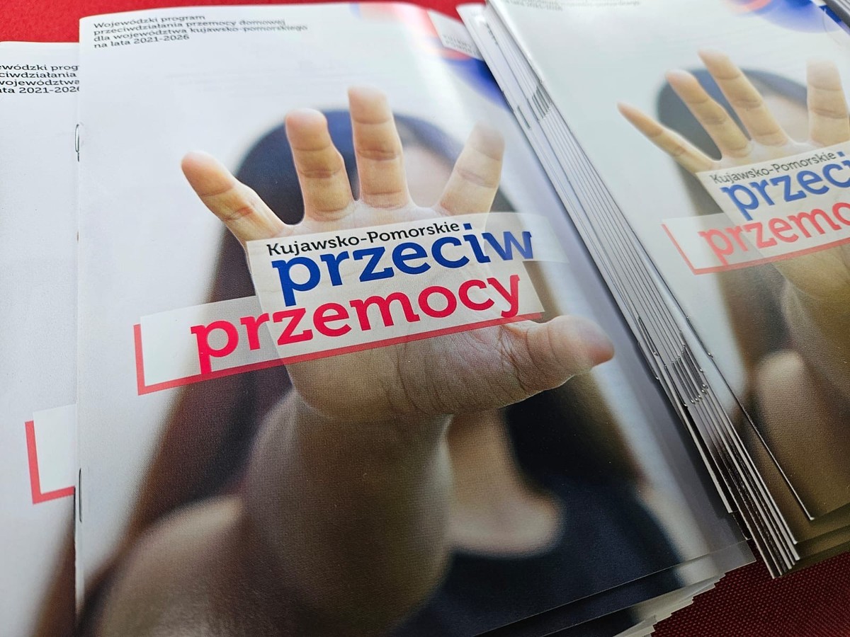 Broszury z otwartą dłonią na okładce oraz napisem: Kujawsko-Pomorskie przeciw przemocy.