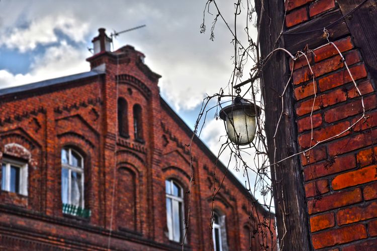 Budynek z charakterystyczną ścianą ryglową (czerwona cegła i deskowanie).