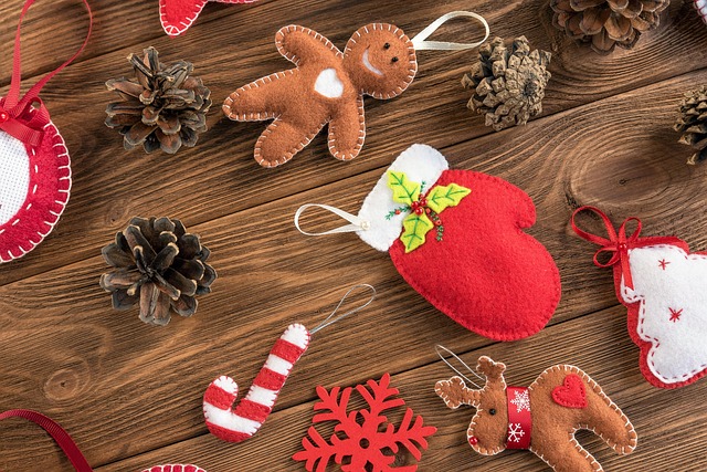 Kolorowe filcowe ozdoby świąteczne: renifer, piernik, choinka, gwiazdka, między nimi szyszki.