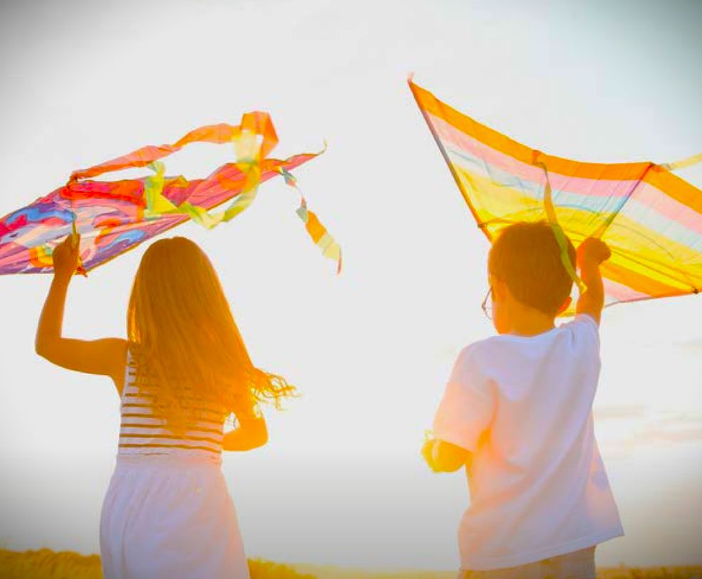 Dzieci puszczające latawce (widok z tyłu).