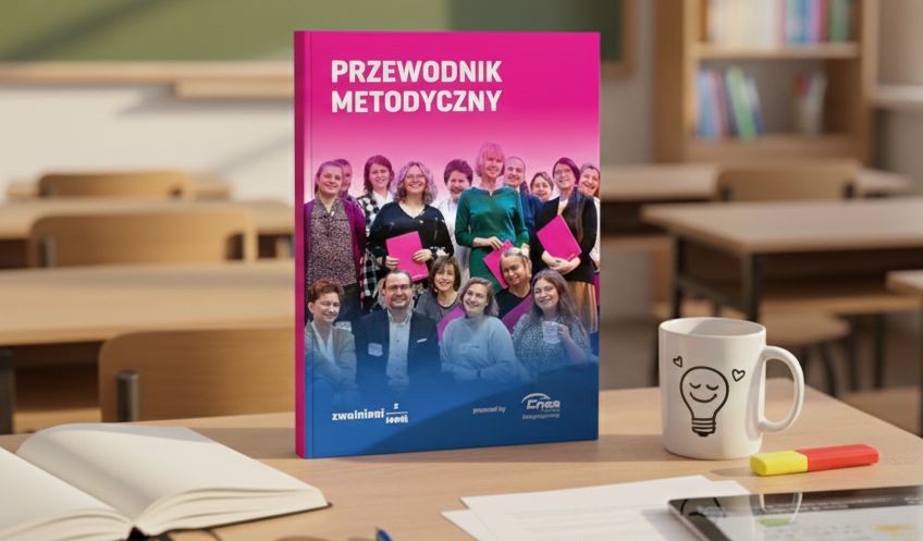 Przewodnik metodyczny - książka postawiona na ławce szkolnej w klasie.