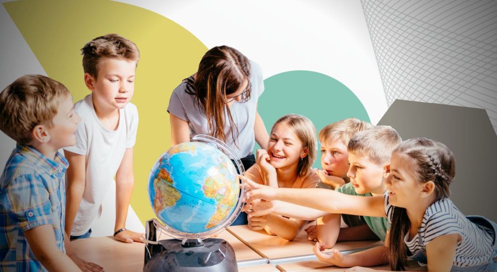 Uczniowie i uczennice przy stoliku z globusem.