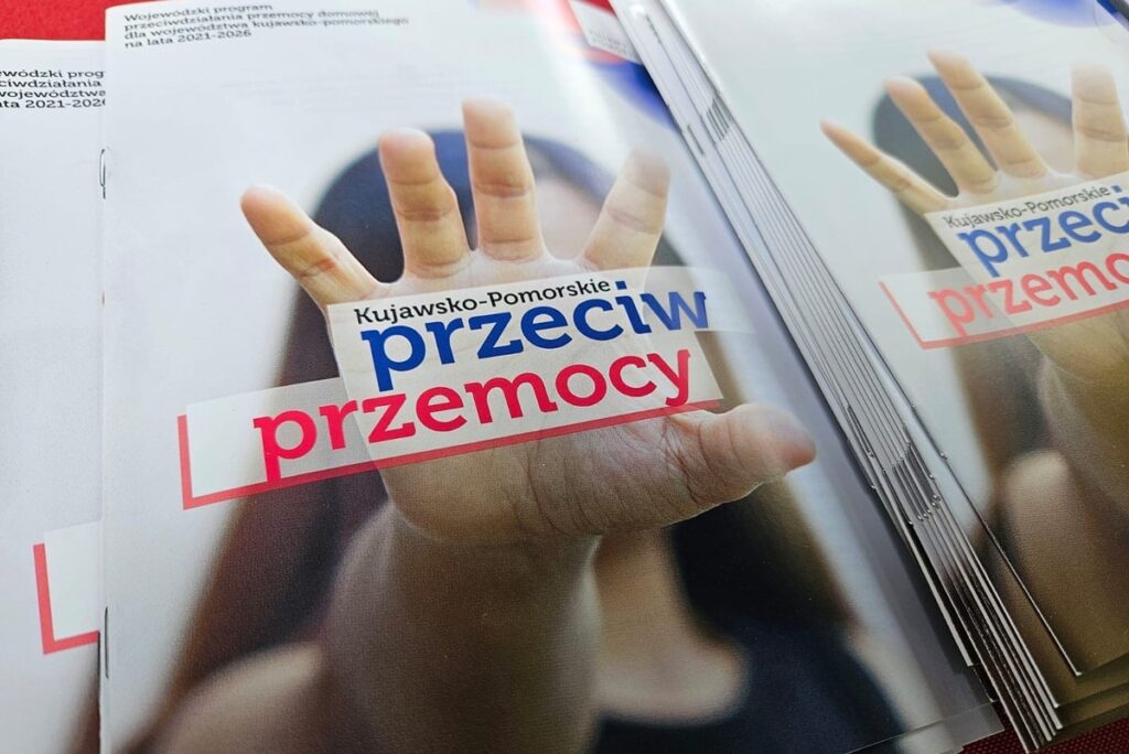 Broszury Kujawsko-Pomorskie przeciw przemocy z motywem wyciągniętej dłoni.