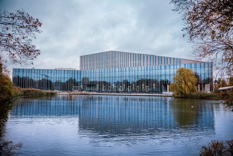 Widok na nowoczesny budynek Akademii Muzycznej od strony stawu.