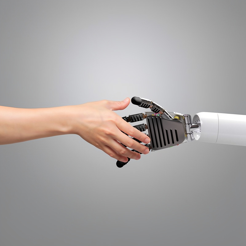 Uścisk dłoni człowieka i androida.