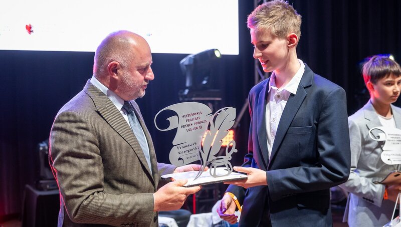 Marszałek wręcza statuetkę stypendyście.