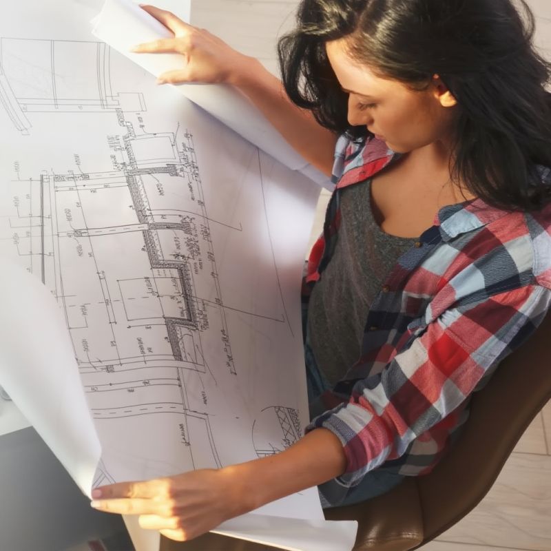 Kobieta patrzy na plany budynku.