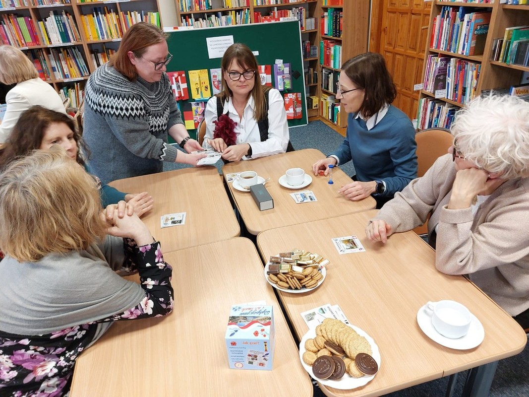 Grupa kobiet siedzi przy stole w bibliotece.
