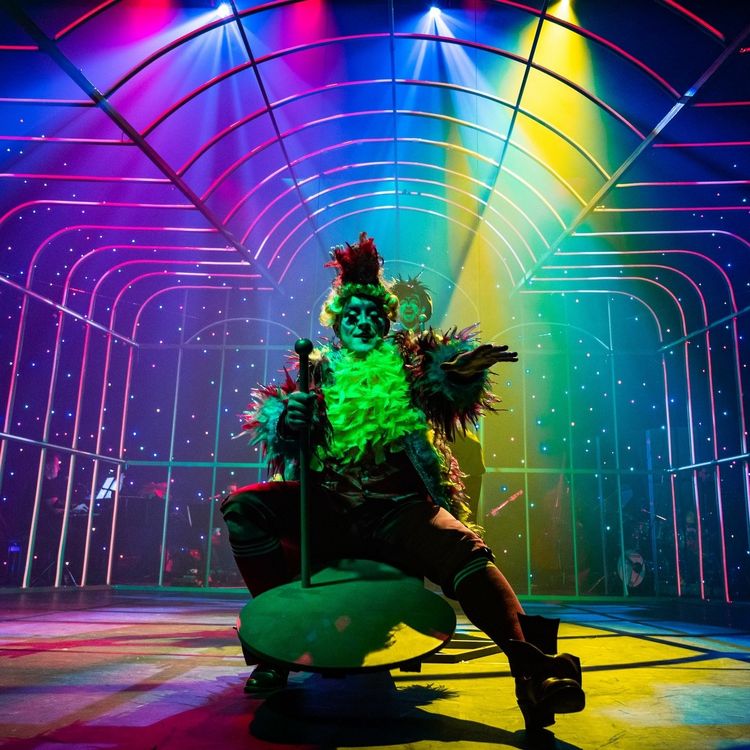 Aktor na scenie w świetle kolorowych reflektorów.