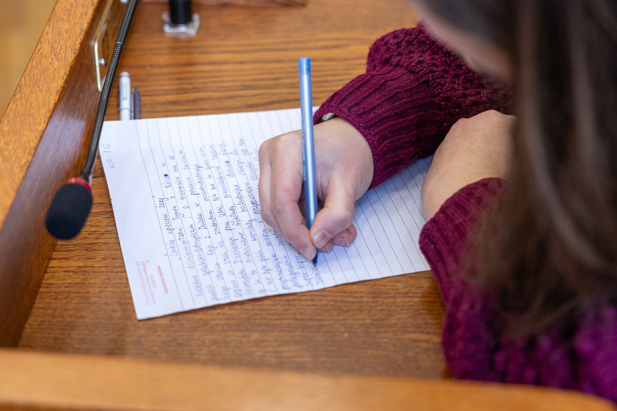 Zbliżenie na kobietę piszącą dyktando.