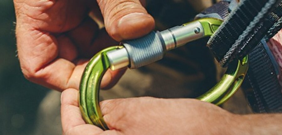 Zbliżenie na dłonie i karabińczyk z taśmami.