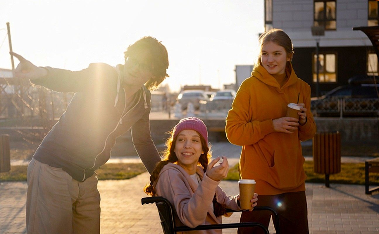 Trzy osoby, w tym jedna na wózku inwalidzkim.