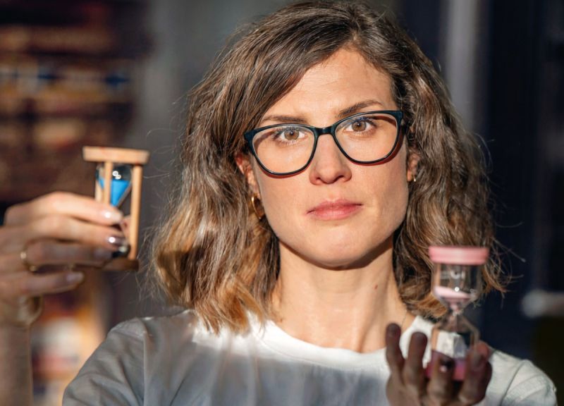 Kobieta trzyma dwie klepsydry.