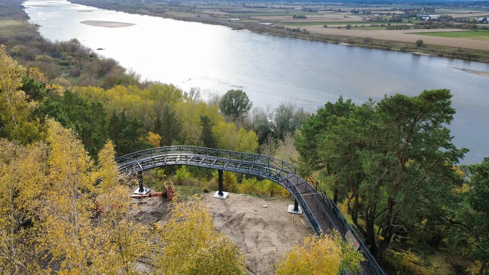 Widok z góry na pola, część lasu i rzekę.