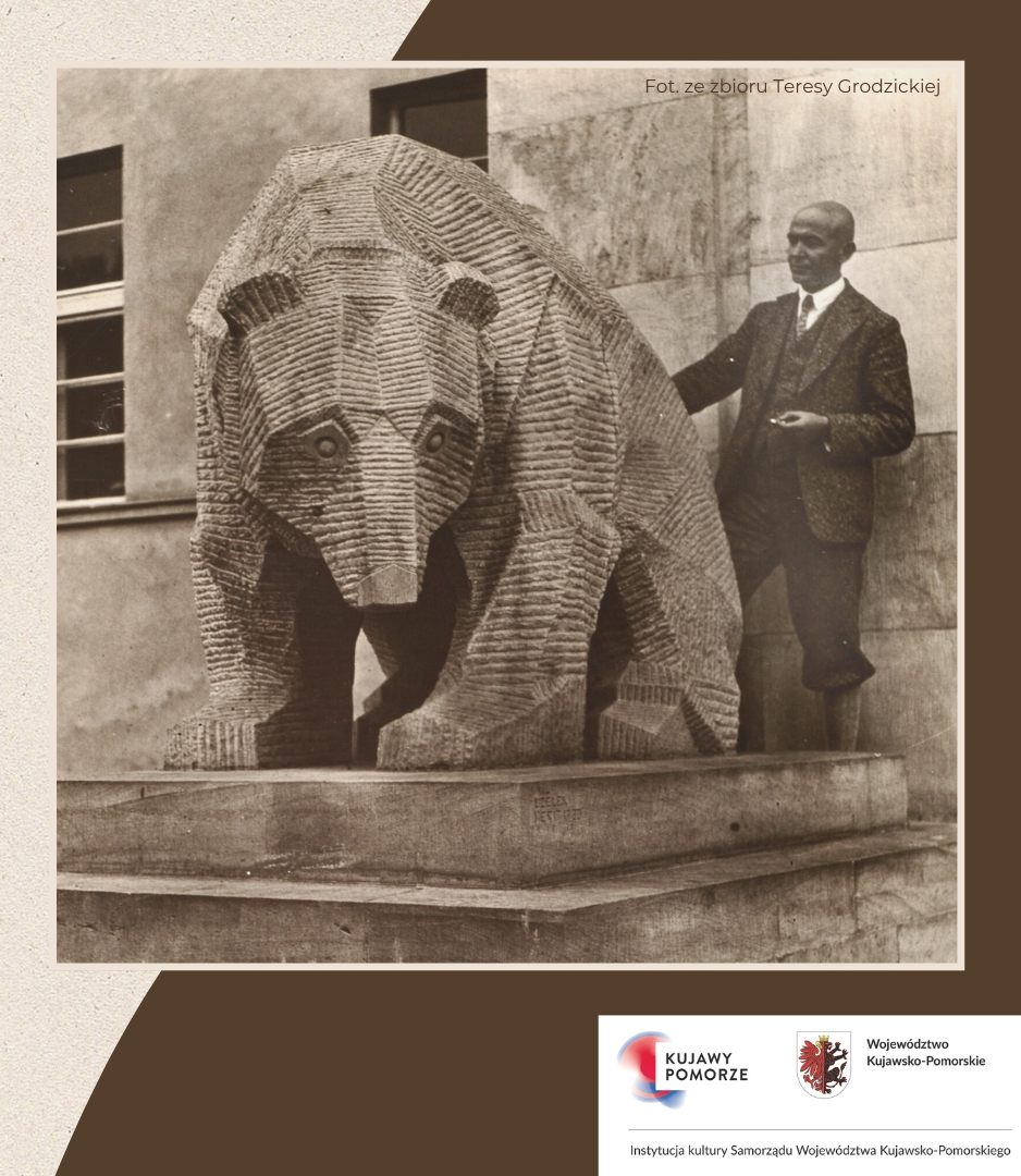 Mężczyzna oraz rzeźba niedźwiedzia.