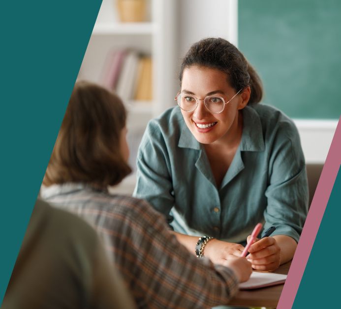 Kobieta w klasie szkolnej zwraca się do uczennicy.