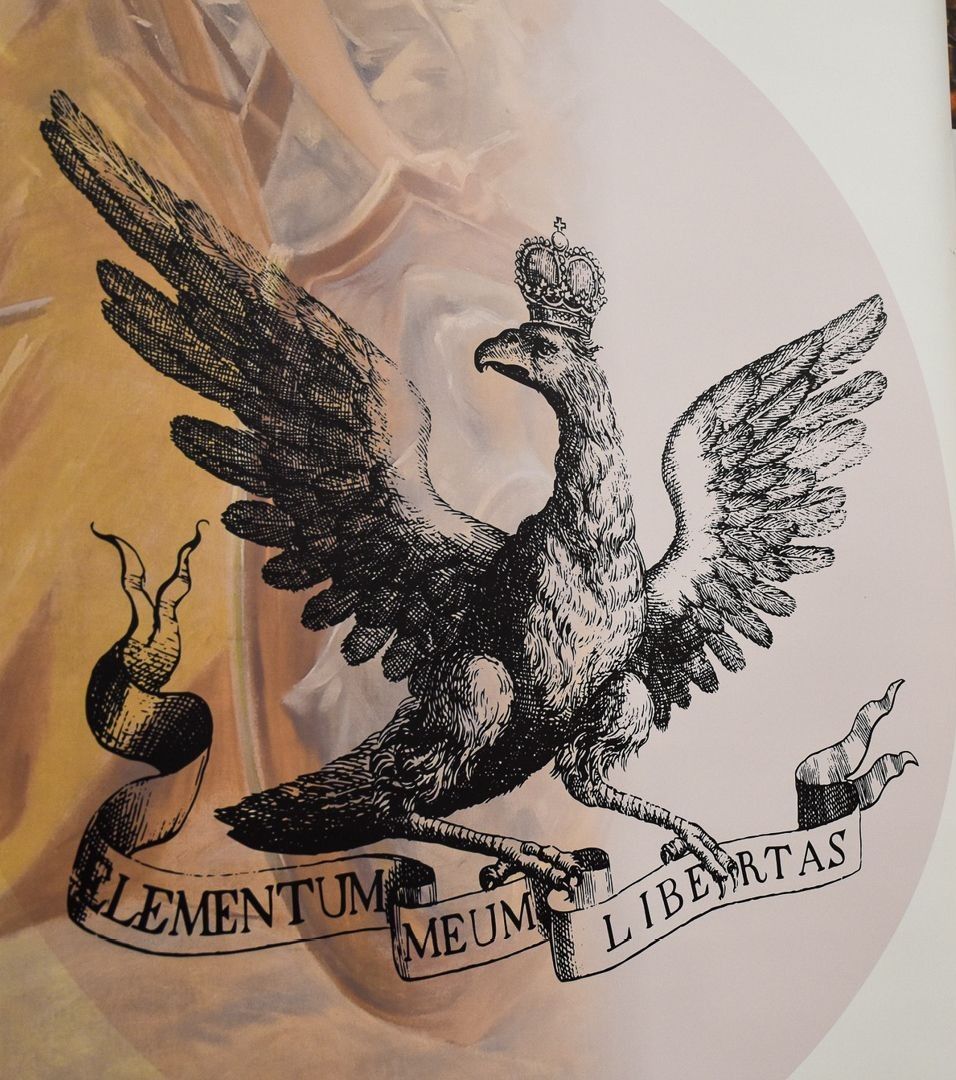 Orzeł w koronie ze wstęgą w szponach.