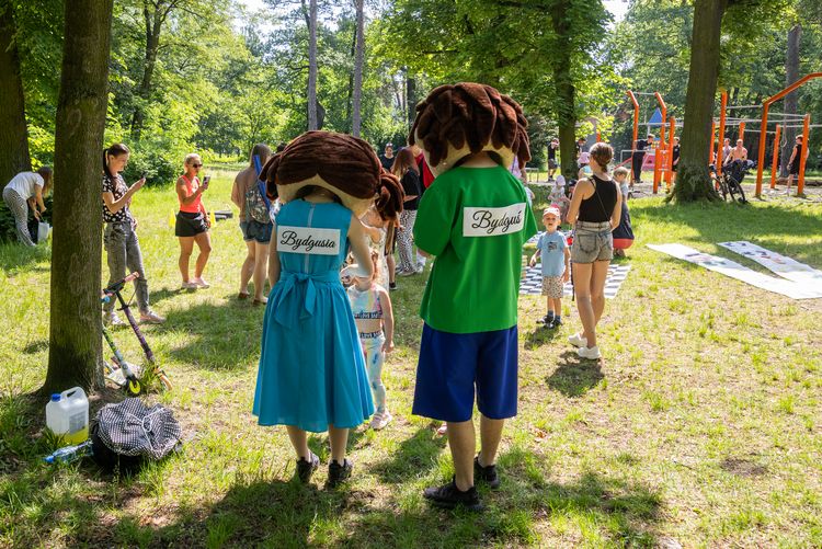 Dzieci i dorośli na pikniku w parku.