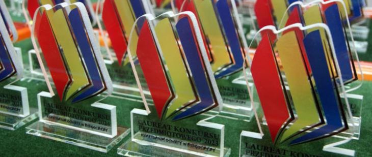 Statuetki laureata konkursu przedmiotowego z logo kuratorium oświaty.