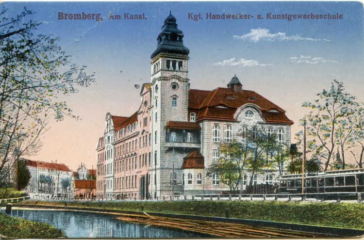 Zabytkowy gmach szkoły przy rzece.