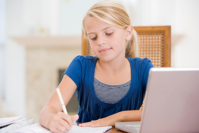 Uczennica odrabia zadanie domowe, korzystając z laptopa